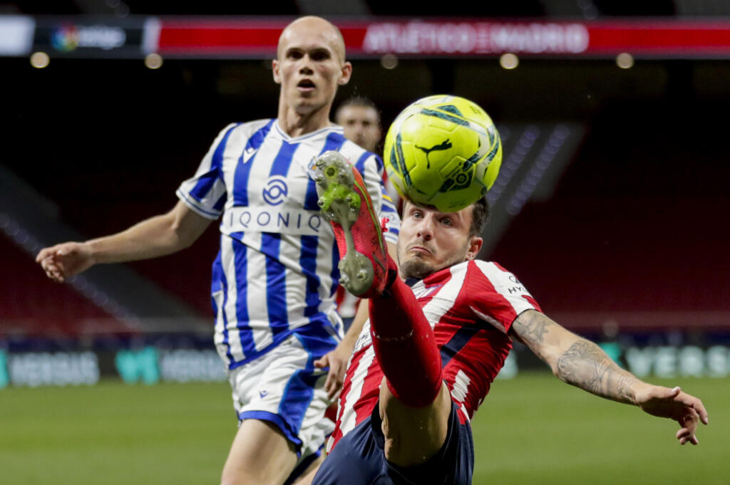 Futbalista Saul (vpredu) z Atletica Madrid kontroluje loptu v zápase 36. kola španielskej futbalovej La Ligy Atletico Madrid - Real Sociedad
