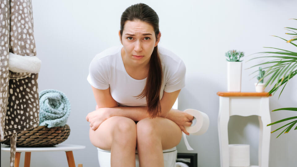 Young,Woman,Suffering,From,Constipation,On,Toilet,Bowl,At,Home