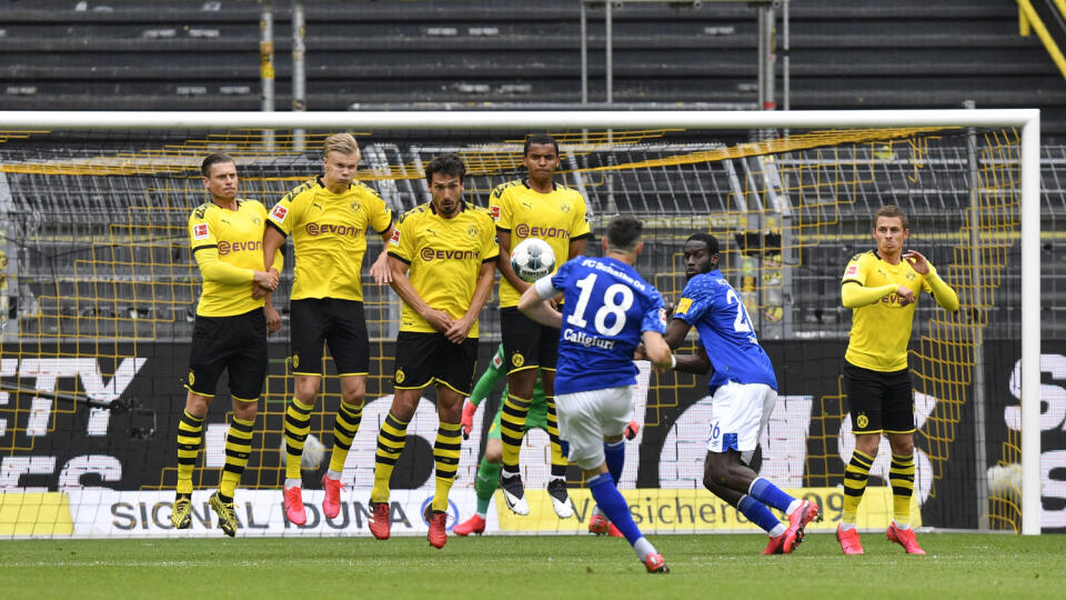 JB 28 Dortmund - Hráč Schalke Daniel Caligiuri (uprostred) strieľa voľný kop počas futbalového zápasu nemeckej Bundesligy Borussia Dortmund - Schalke 04 v Dortmunde 16. mája 2020. Nemecká bundesliga bude za prísnych hygienických a bezpečnostných opatrení pre pandémiu nového koronavírusu pokračovať od soboty 16. mája, zvyšok sezóny sa dohrá bez divákov. FOTO TASR/AP

Schalke's Daniel Caligiuri, center, shoots a free kick during the German Bundesliga soccer match between Borussia Dortmund and Scha