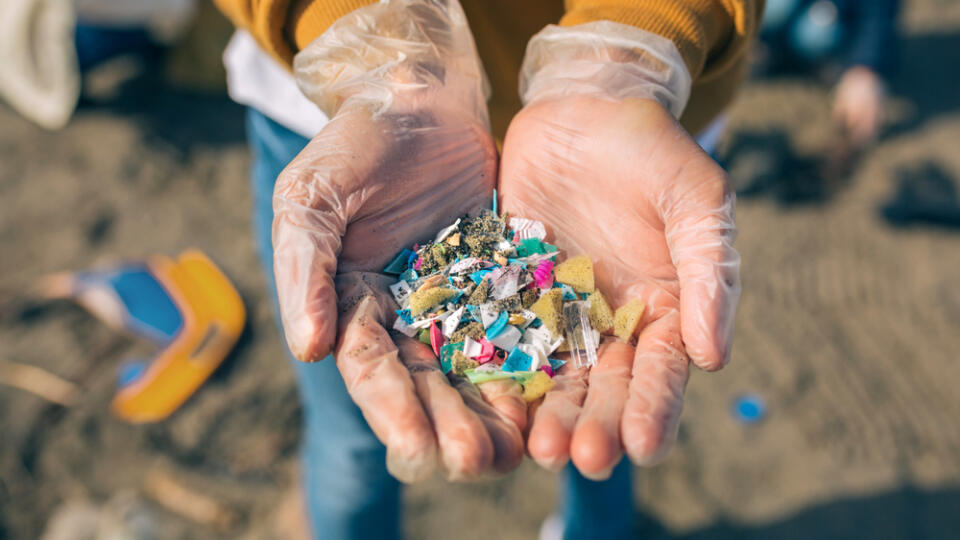 Detail,Of,Hands,Showing,Microplastics,On,The,Beach