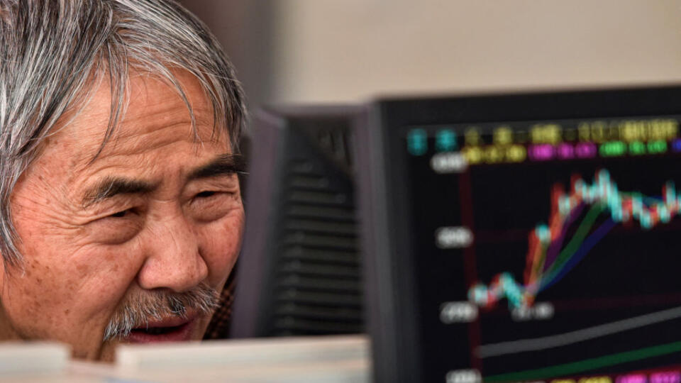 A trader watches the Shanghai Composite Index on a monitor