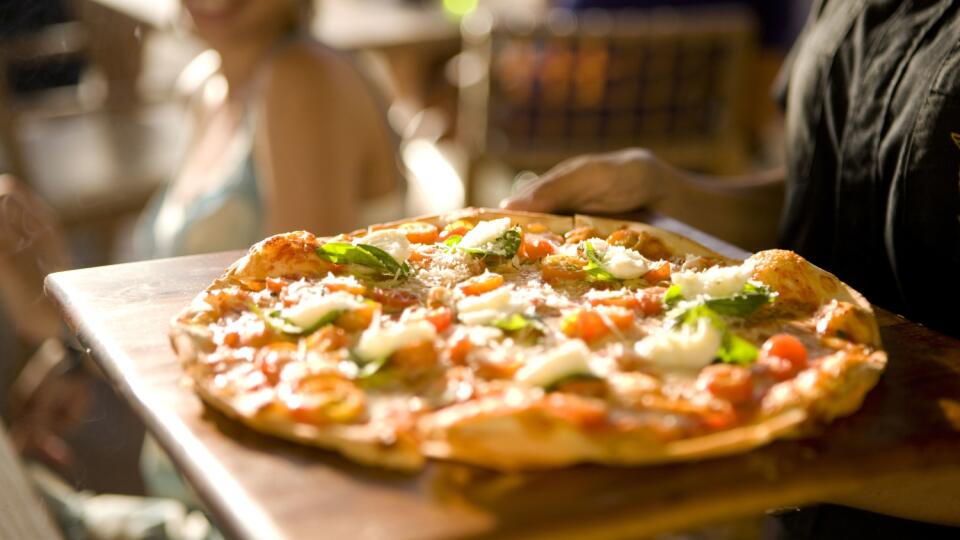 Serving pizza, woman in background smiling, canon 1Ds mark III