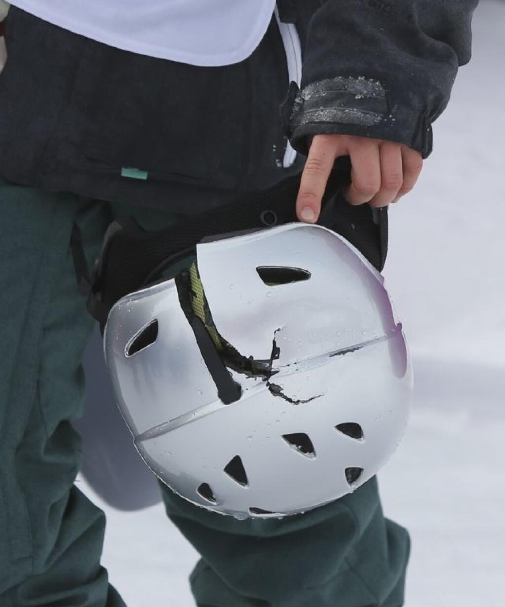 Czech Republic's Sarka Pancochova holds her smashed helmet after she crashed during the women's snowboard slopestyle final at the 2014 Winter Olympics, Sunday, Feb. 9, 2014, in Krasnaya Polyana, Russia. (AP Photo/Sergei Grits)