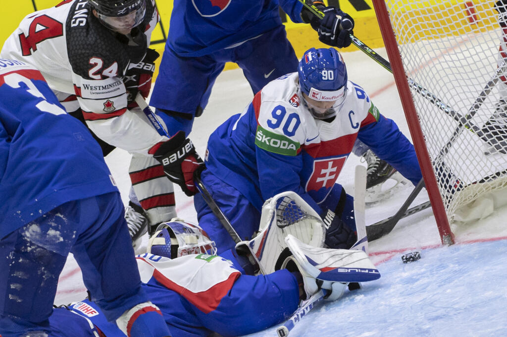 Na snímke dole brankár Adam Húska, vpravo kapitán Tomáš Tatar (obaja Slovensko) a hore vľavo Dylan Cozens (Kanada) v zápase základnej A - skupiny Slovensko - Kanada na 85. majstrovstvách sveta v ľadovom hokeji v Helsinkách v pondelok 16. mája 2022.