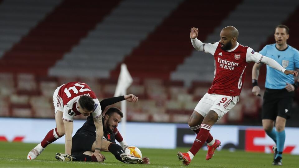 JB 12 Londýn - Hráč Arsenalu Granit Xhaka (vľavo) zastavuje Slováka Jakuba Hromadu (druhý zľava) zo Slavie Praha a Alexandre Lacazette z Arsenalu uteká za loptou v zápase štvrťfinále Európskej ligy Arsenal Londýn - Slavia Praha v Londýne 8. apríla 2021. FOTO TASR/AP
Arsenal's Granit Xhaka, left, stops Slavia Prague's Jakub Hromada, bottom, as Arsenal's Alexandre Lacazette goes for the ball during the Europa League quarterfinal soccer match between Arsenal and Slavia Prague at Emirates stadium i