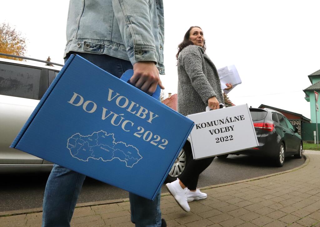 Na Slovensku sa v sobotu o siedmej hodine ráno začali historicky prvé spojené voľby do orgánov samosprávy obcí a do orgánov samosprávnych krajov. Na snímke členovia volebnej komisie nesú prenosné volebné schránky v Sliači v okrese Zvolen 29. októbra 2022. FOTO TASR - Ján Krošlák