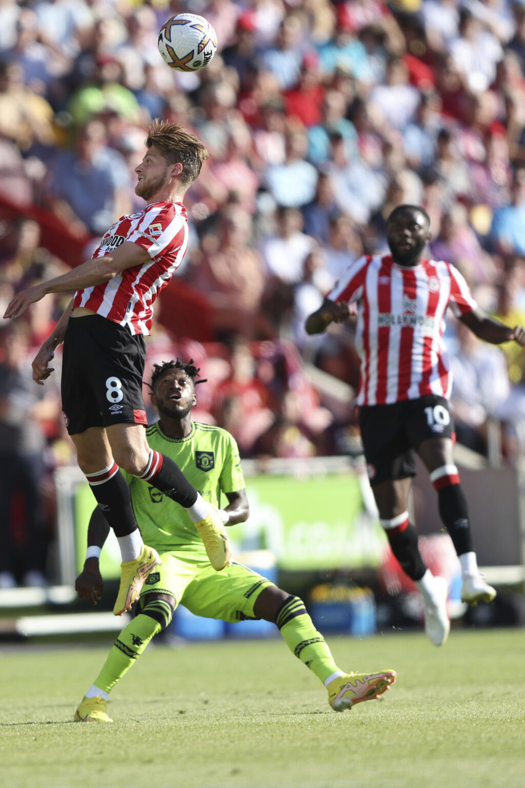 Hráč Brentfordu Mathias Jensen (hore vľavo) hlavičkuje vo futbalovom zápase anglickej ligy Premier League FC Brentford -Manchester United v Londýne 13. augusta 2022. FOTO TASR/AP