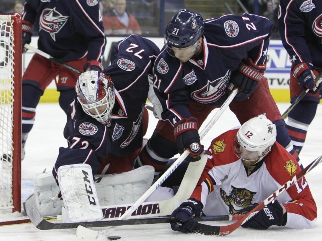 Columbus Blue Jackets' Sergei Bobrovsky, left, of Russia, makes a save as teammate James Wisniewski, center, and Florida Panthers' Jimmy Hayes fight for the rebound during the first period of an NHL hockey game Monday, Dec. 1, 2014, in Columbus, Ohio. (AP Photo/Jay LaPrete)