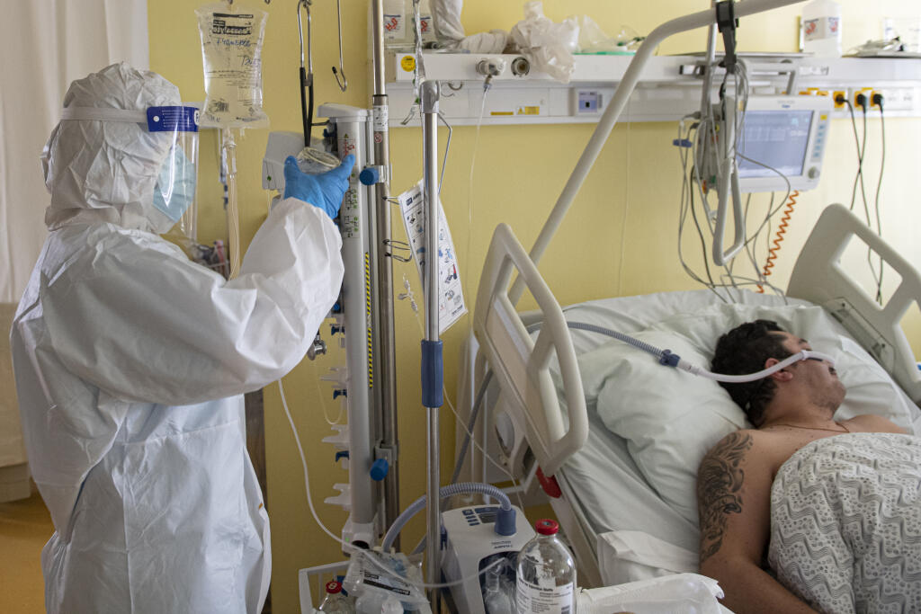 Lekár v špeciálnom ochrannom odeve, s ochranným štítom, respirátorom a ochranným rúškom kontroluje pacienta napojeného na tzv. high flow podporu dýchania na jednotke intenzívnej starostlivosti v COVID červenej zóne na Klinike pneumológie a ftizeológie I. Slovenskej zdravotníckej univerzity (SZU) a Univerzitnej nemocnice Bratislava (UNB) v Ružinove. Bratislava, 25. februára 2021. FOTO TASR - Michal Svítok