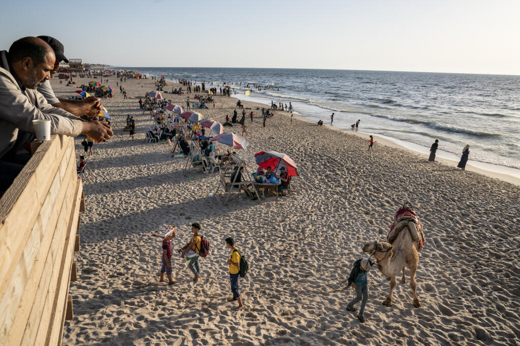 JB 23 Gaza - Muž ponúka zákazníkom ťavu na jazdu na pláži plnej ľudí pri pobreží Stredozemného mora niekoľko dní po vyhlásení prímeria a skončení jedenásťdňovej vojny medzi hnutím Hamas a Izraelom, v Gaze 25. mája 2021. FOTO TASR/AP

A man offer camel rides to customers on the shores of the Mediterranean Sea, as life begins to return to a semblance of normal, days after the end of an 11-day war between Gaza's Hamas rulers and Israel, Tuesday, May 25, 2021, in Gaza City. (AP Photo/John Minchillo)
