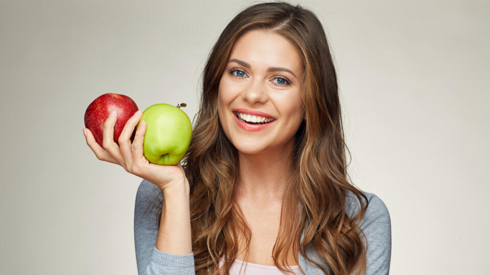 Smiling,Young,Woman,Holding,Two,Apples,,Red,And,Green.,Isolated