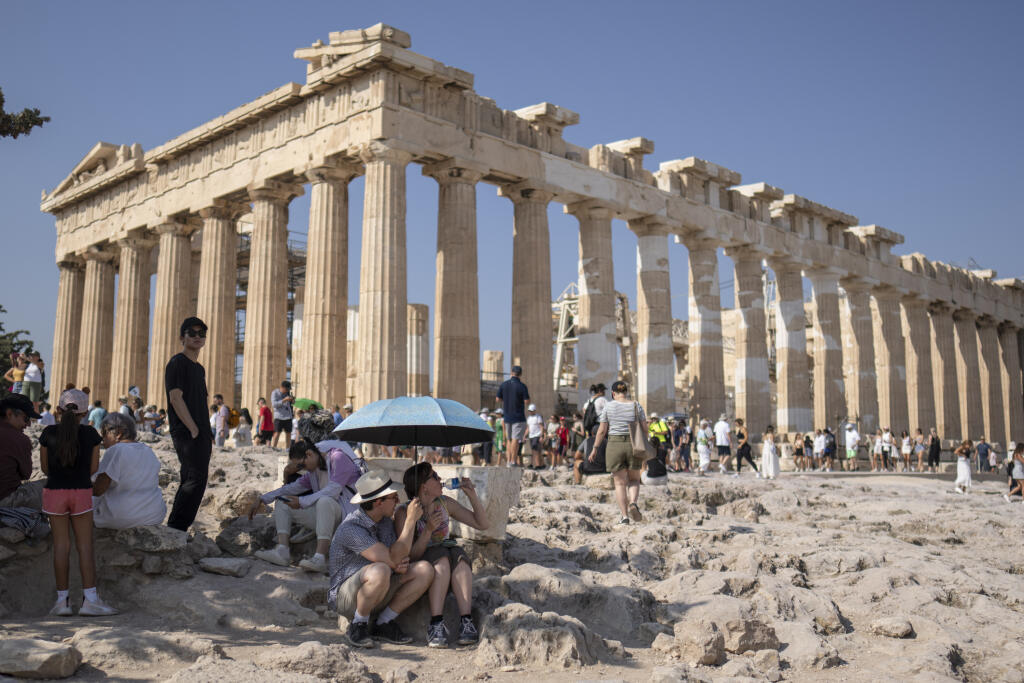 WA 45 Atény - Turisti pijú vodu pod dáždnikom počas horúčav na Akropole v Aténach vo štvrtok 13. júla 2023. Aténsku Akropolu v piatok z dôvodu horúčav na niekoľko hodín zatvoria. Oznámila to grécka ministerka kultúry Lina Mendoniová.   Prístup k aténskej Akropole, ktorá je na zozname svetového dedičstva UNESCO, nebude možný od 12.00 h do 17.00 h miestneho času (11.00 až 16.00 h SELČ), povedala Mendoniová pre grécku televíziu ERT. Opatrenie podľa jej slov prijali na ochranu zdravia turistov. FOTO