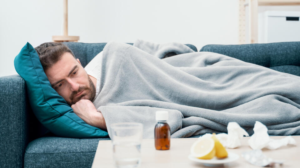 Man,Wrapped,In,Plaid,Lying,On,The,Sofa,Feeling,Sick